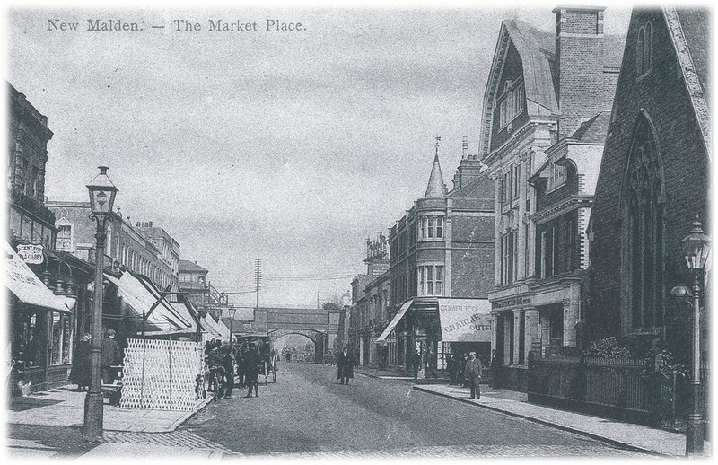 Photograph postcard bearing the title 'New Malden - Market Place', looking north towards the railway bridge; Holy Trinity is visible on the right where Waitrose now is.