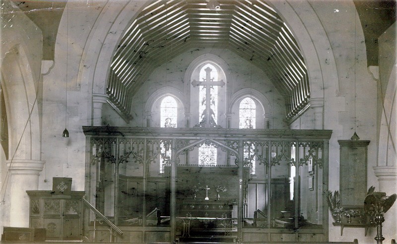 Photo showing the Oak Screen in front of the chancel, with the pulpit on the left and names tablet on the right