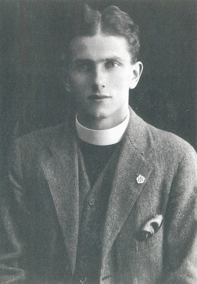 Photo of the young Bryan Green in a dog collar; a lapel badge in the shape of a shield is visible with a letter 'K' superimposed on a letter 'O'