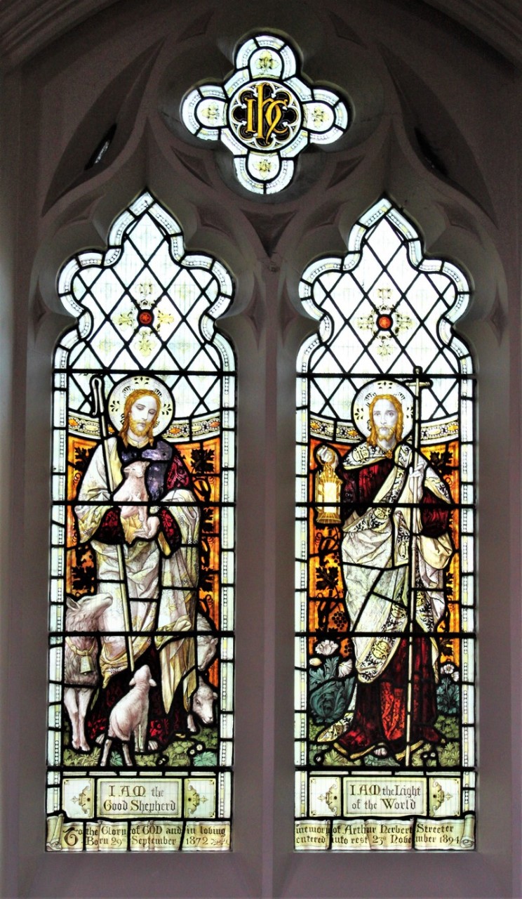 Photo of the stained glass window depicting Jesus as the Good Shepherd, holding a lamb (I AM the Good Shepherd) and as the Light of the World, holding a lantern (I AM the Light of the World)