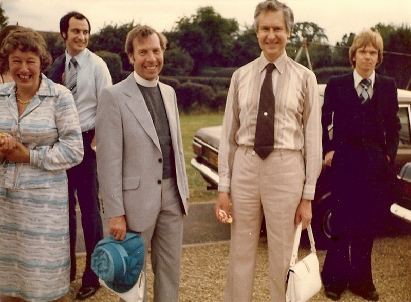 Photo of Peter Coombs and Norman Taplin at a wedding, Peter holding his wife's hat, and Norman his wife's handbag