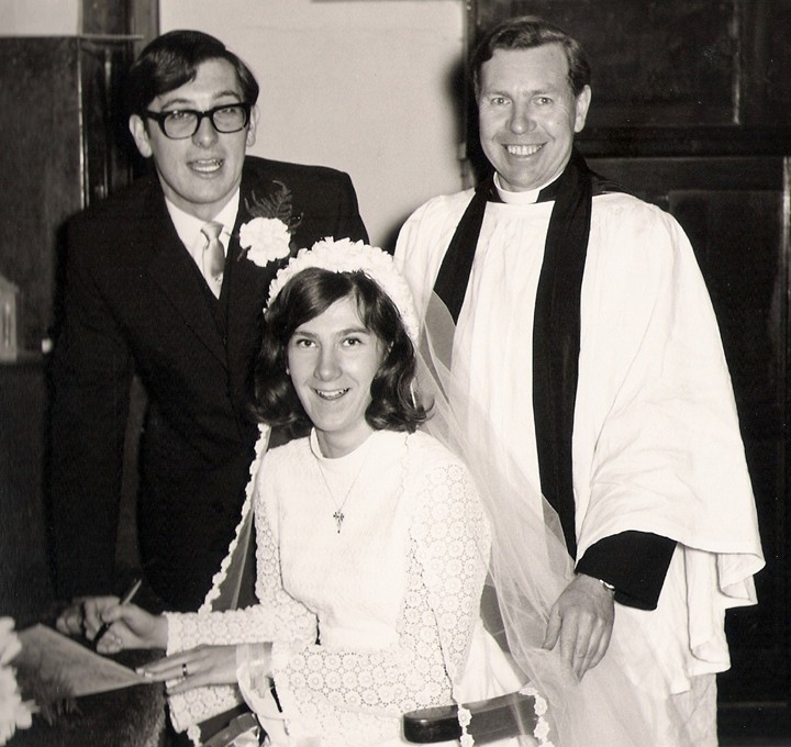 Photo of Andrew and Margaret Rankin at the signing of the registers at their wedding, with Peter Coombs