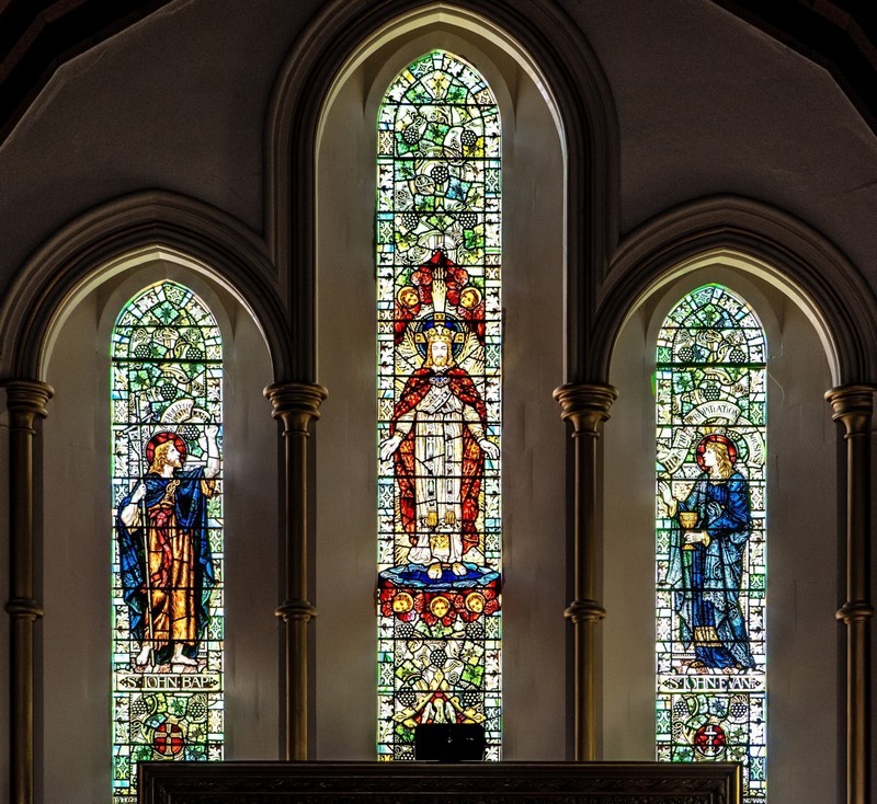 Photo of the stained glass window in the East Wall showing John the Baptist (on the left) and John the Evangelist (on the right) witnessing to Jesus (in the centre) the Risen Saviour