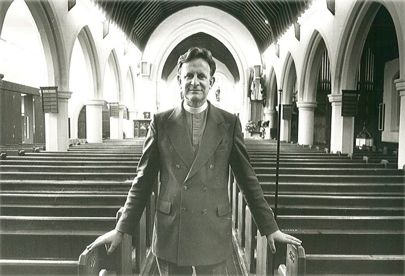 John Short in the Nave at Christ Church, hands on the pews either side of the aisle