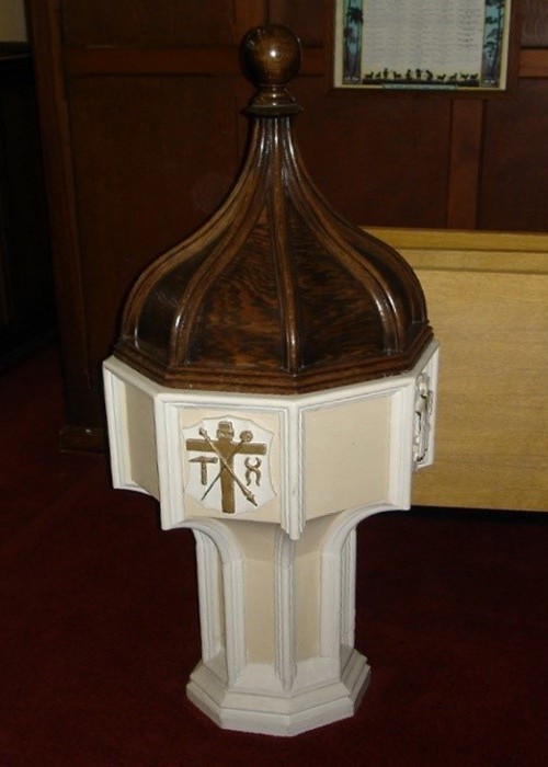 Photo of the Baptismal Font of white marble and a domed wooden top