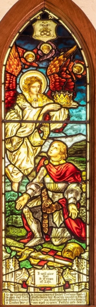 The 'I will give thee a Crown of Life' window, depicting a medievel knight, his sword and helm beside him on the ground, kneeling as an angel is about to set a golden crown on his head