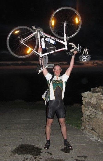 A lycra-clad Tudor Morris holds his bike above his head after the 2010 cycle ride