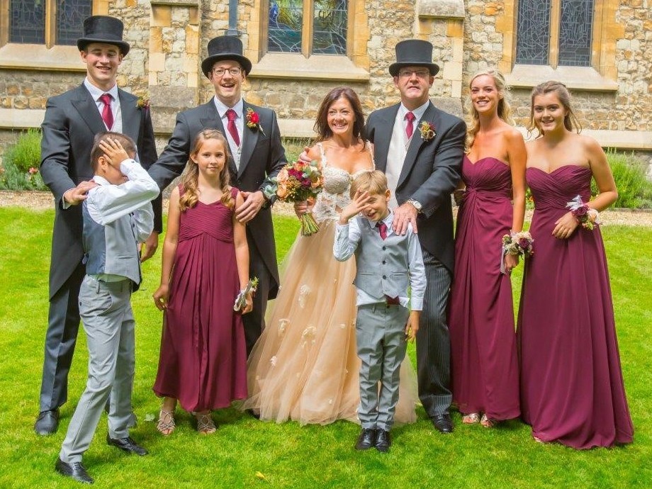 Wedding photo of John and Georgie Morris with Tudor as Best Man, Dylan as usher, Daisy, Leila and Poppy as bridesmaids and Greg and Felix as pageboys