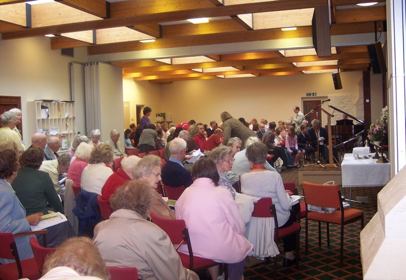 Photo taken just before a service held in the Lounge, congregation seated in semi-circular rows