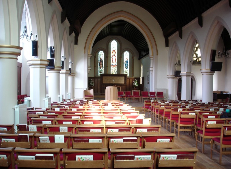 Photo of the church interior following the re-ordering, looking east with the new chairs in place either side of the aisle