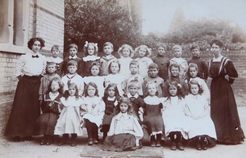 Photo of the early Sunday School, three rows of school children dressed smartly, flanked by well-dressed lady Sunday School teachers