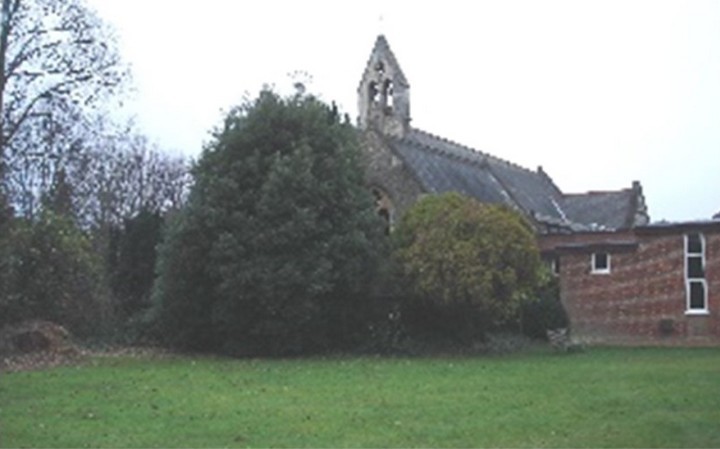 Photo of the church from 2004 showing its east wall; the tree has completely obscured the window