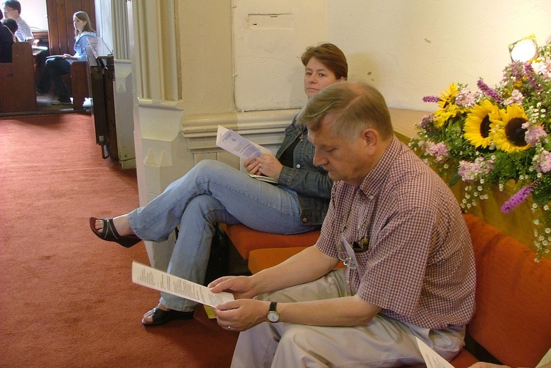Photo of Trevor Webster and Carolyn Lucas sat at the back of the church before the start of a service